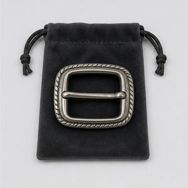 Antique silver belt buckle presented on a charcoal velvet pouch